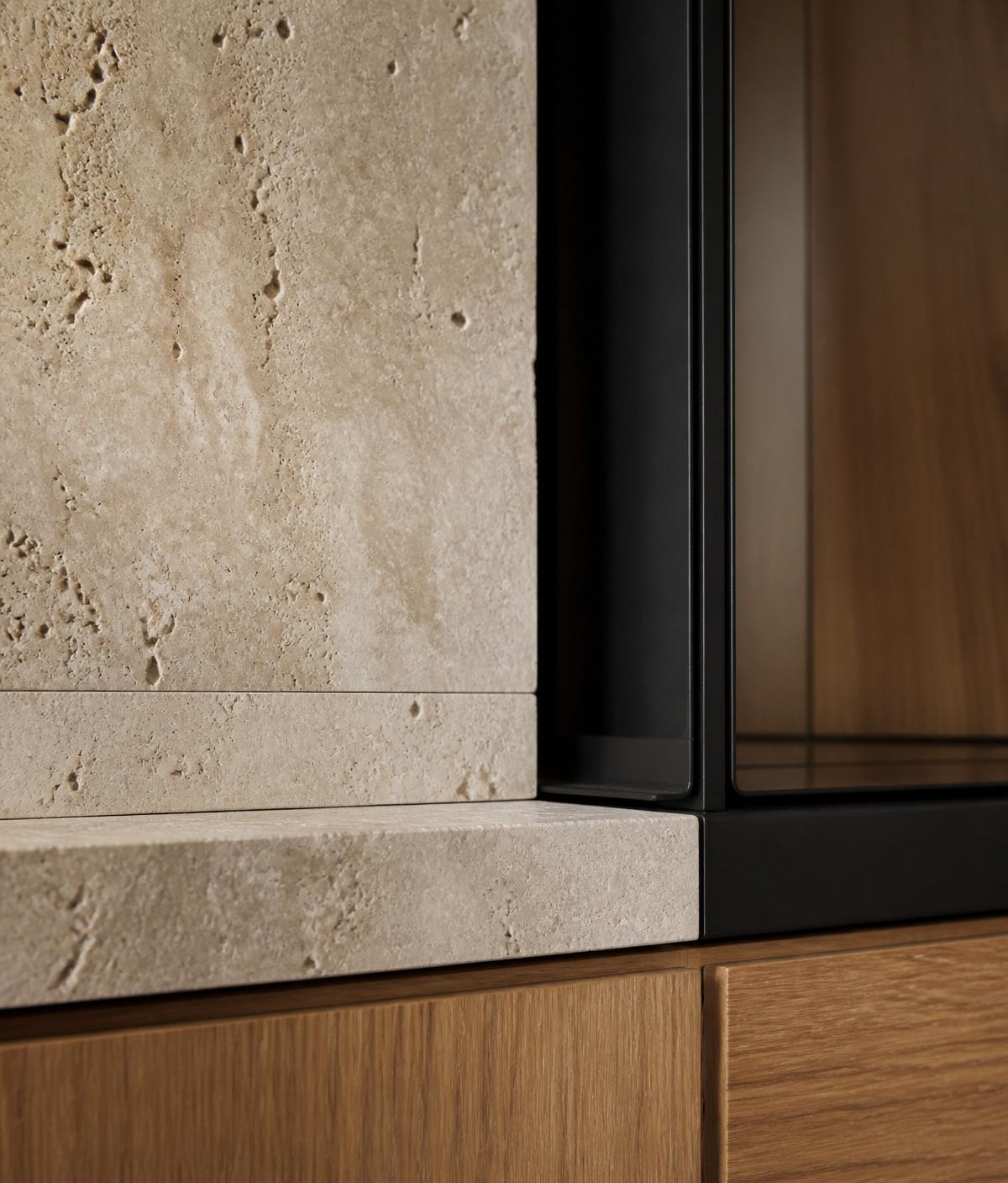 Travertine, warm oak and matte black material detail